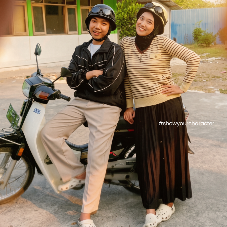 Sepasang pengendara memakai helm Retrograde di samping motor bebek